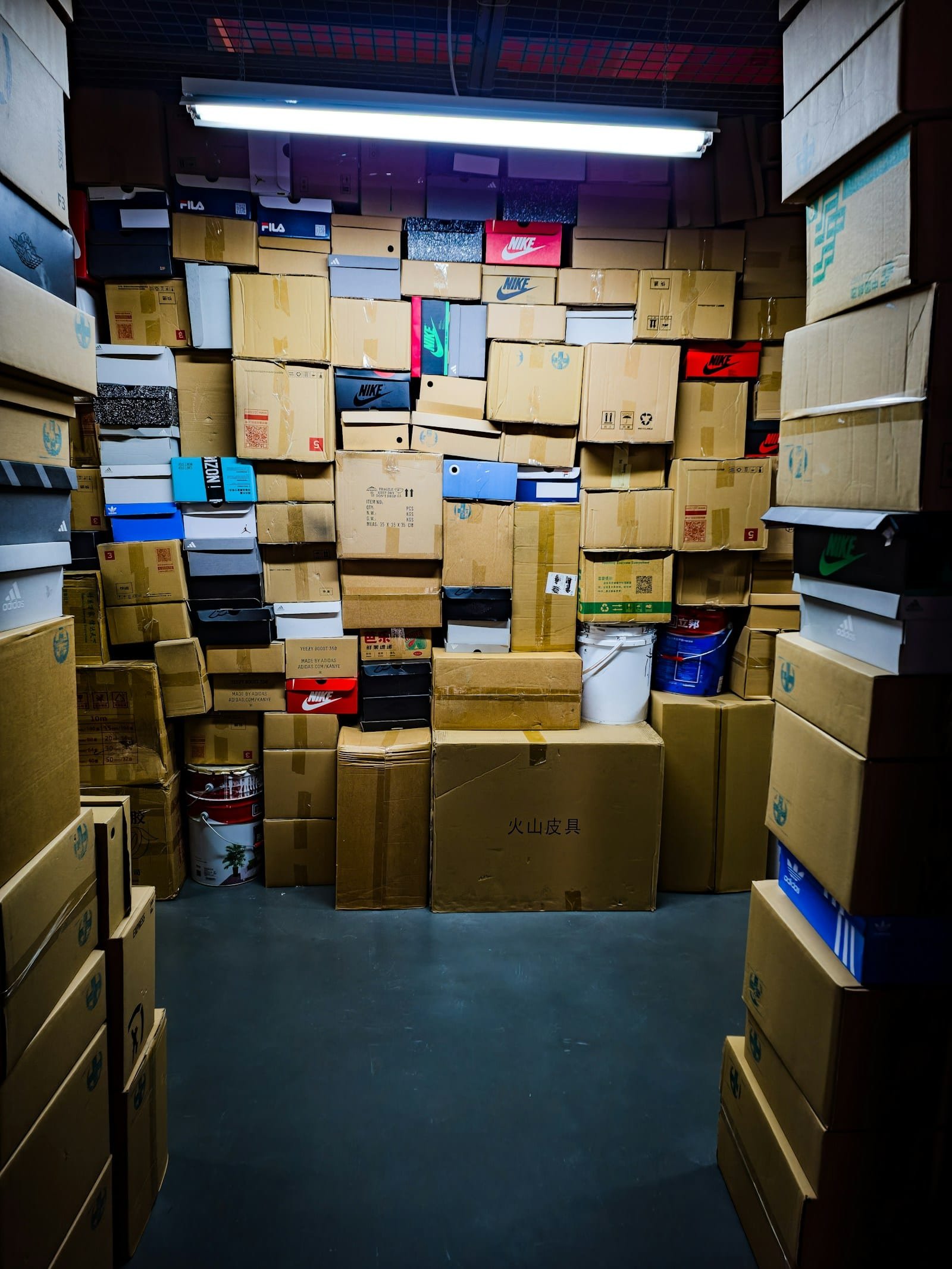 Transfert d'archives : inventaire, étiquetage et ordre de rangement respectés Pièce remplie de cartons et de boîtes empilés du sol au plafond