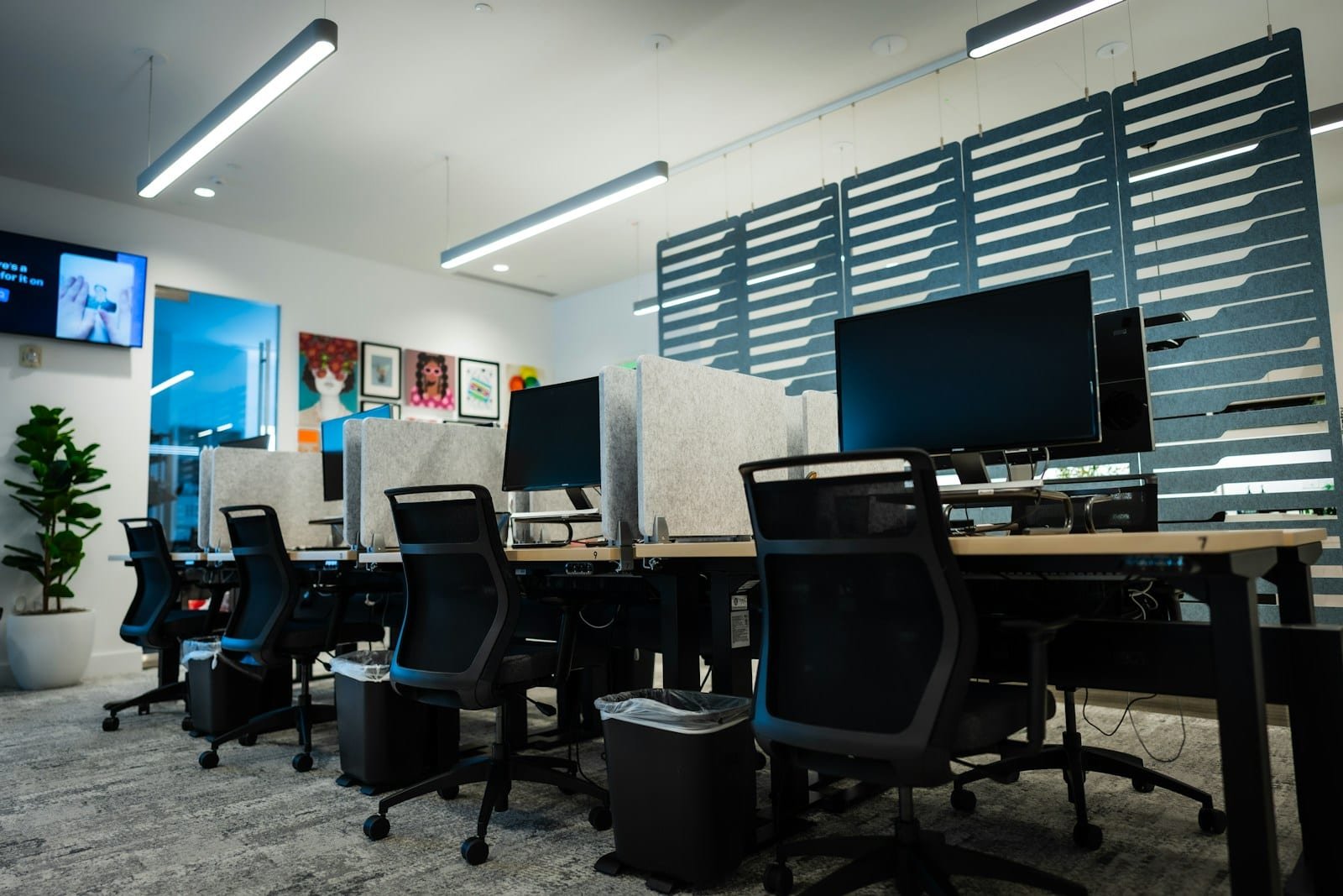 Transfert d'entreprise : des postes opérationnels dès la reprise Plateau de bureaux moderne avec postes de travail, écrans et fauteuils de bureau
