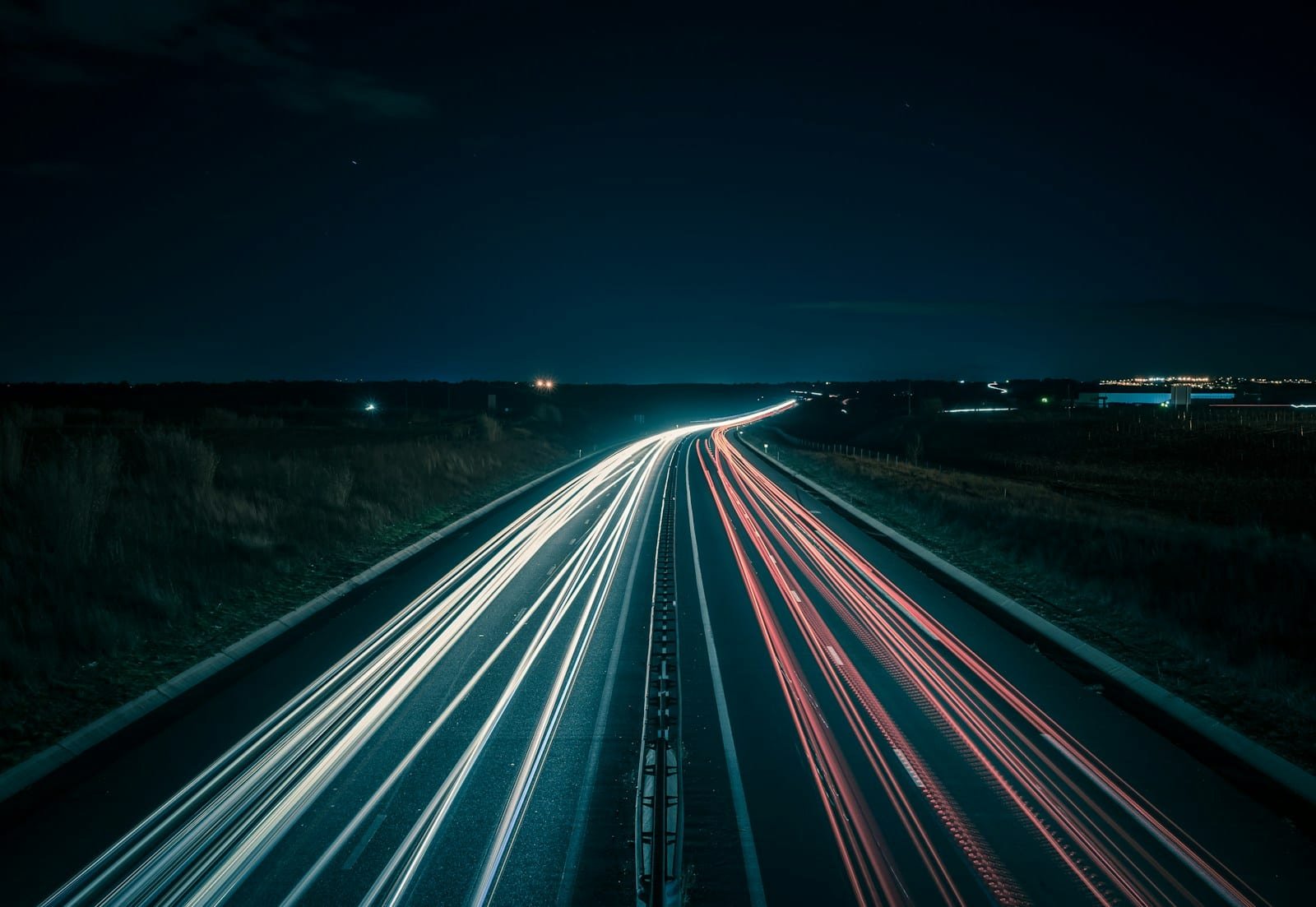 Autoroute de nuit photographiée en pose longue, traînées lumineuses des véhicules, près de Montpellier