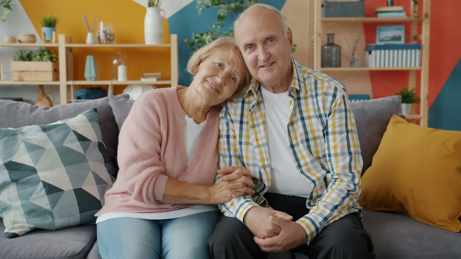 Déménagement senior : un accompagnement attentif à chaque étape Couple de seniors souriants assis côte à côte sur un canapé dans leur salon